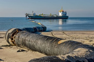 Westenschouwen, Hollanda, 26 Ekim 2024: Sahil savunma çalışmaları sırasında sahil şeridine doğru maliyetin dışında bir hopper dredger önde gelen boru hattı