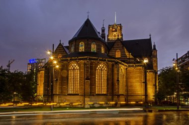 Rotterdam, Hollanda, 1 Ekim 2024: Sint Laurens Kilisesi, şehir merkezindeki en eski bina, mavi saatte bitişiğindeki meydanda hafif raylar.
