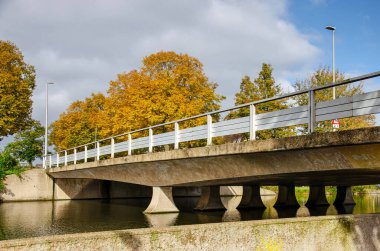 Concrete bridge across a canal in Capelle aan den IJssel, The Netherlands, on a sunny day in autumn clipart