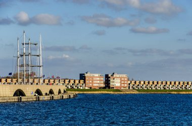 Lelystad, Hollanda, 29 Mart 2025: Markermeer Gölü 'nden Bataviahaven Marina' ya ve rıhtımdaki konut binalarına doğru.