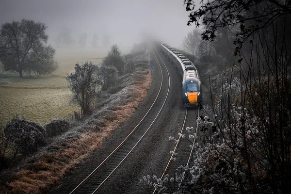 Kış manzarası ve sisten gelen bir tren. Buzla kaplı tarlalar. Görüntü: Dundas Aqueduct, İngiltere.