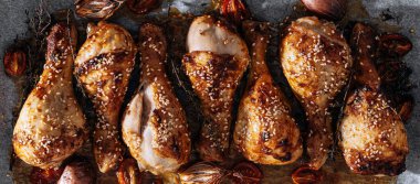 baked chicken drumsticks with sesame, honey and soy sauce, onion and spices