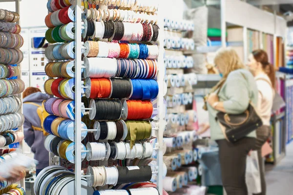 Woman shoppers choose fabric goods in textile store