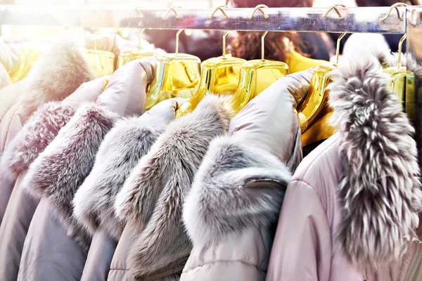Winter jackets with grey fur collars in the clothing store