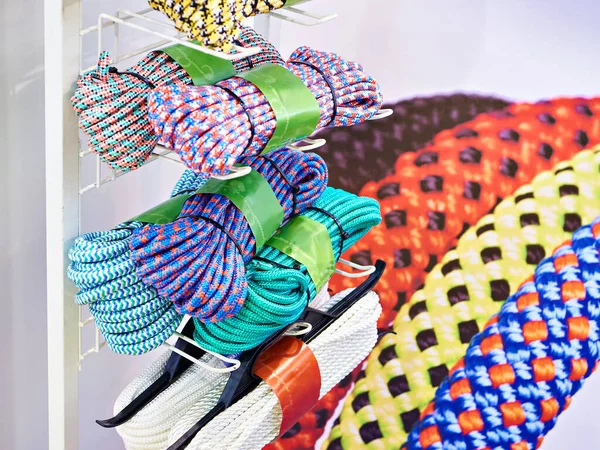 Skeins of colored ropes and cords on display in a store