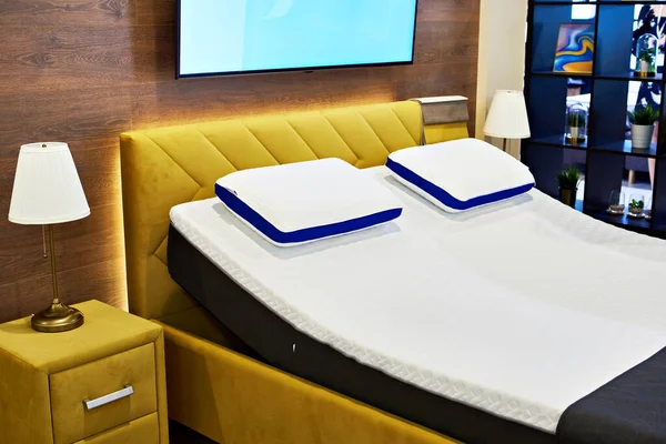 Modern beds with mattresses and pillows in the store