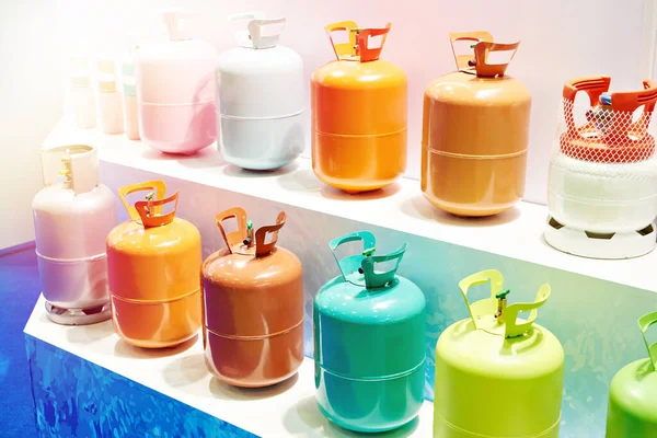 Metal colored refrigerant gas tanks on display in a store