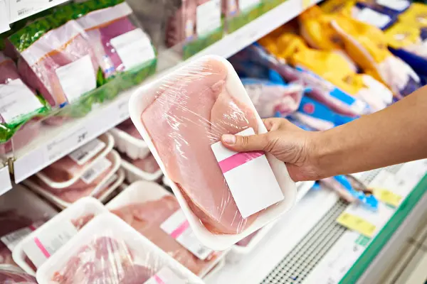 Human hands with turkey meat in the store