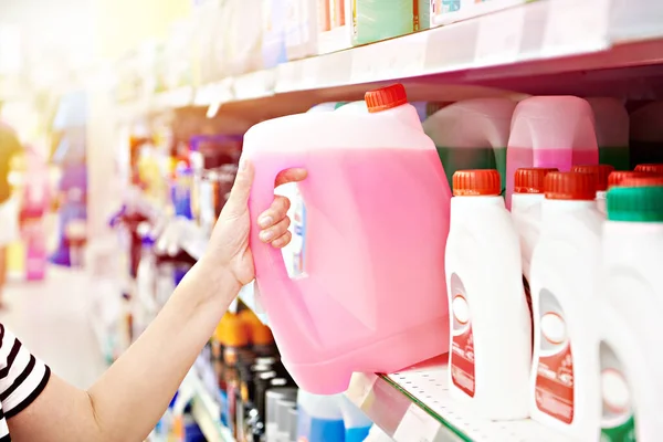 Woman hand with windshield washer fluid in supermarket