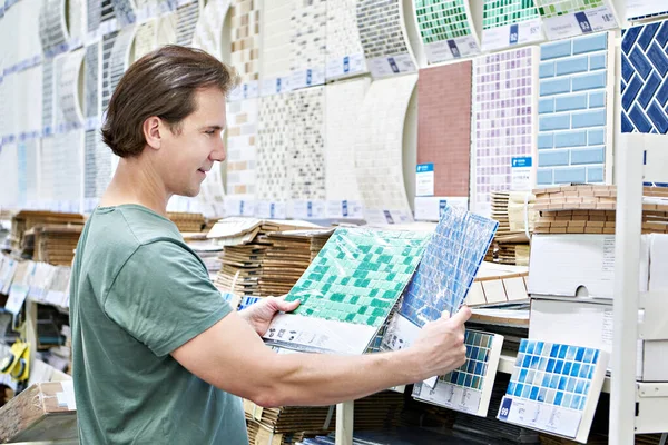 Man buying ceramic wall tiles in construction store