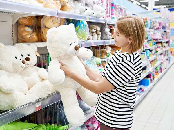Woman in a toy store buys a big bear