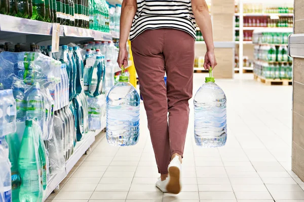 Woman shopper with bottles of water in store