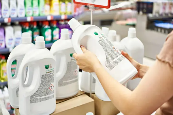 Plastic bottle with laundry liquid in hand in store