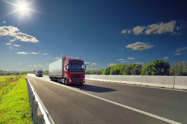 Gün batımında kırsal alanda bir otoyol üzerinde büyük bir nakliye kamyonu.
