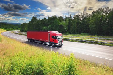Kırsal kesimden geçen bir otoyolda büyük bir nakliye kamyonu.