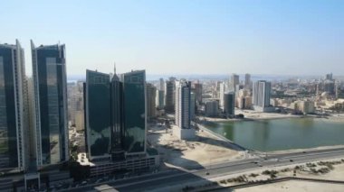 Manama, Bahreyn 'in Alfateh ilçesindeki yüksek katlı apartman kompleksleri ve otellerin yanından bir kamera dronu geçiyor.