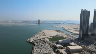 Bir kamera İHA 'sı Al Najmah Kulüp Spor Merkezi' nin üzerinden Prens Halife bin Salman Köprüsü, Manama Bahreyn 'e doğru ilerliyor.