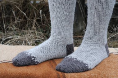 Jacquard desenli gri yüksek çoraplar giyen bir kız. Yan görünüm.