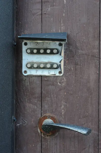 Eski kapı kolu ve kombinasyon kilidi ahşap bir kapıda, stok fotoğrafı.