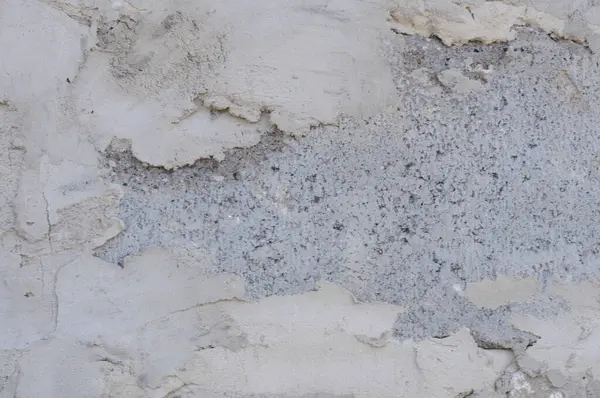 Eski kırsal duvarın dokusu gri alçıyla kaplıydı.