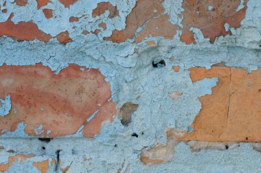 Eski kırsal duvarın dokusu mavi ve turuncu sıva ile kaplıdır.