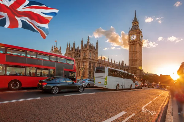 ロンドン イギリス イギリスのカラフルな夕日に対するイングランドの橋と旗の上にバスとビッグベン — ストック写真