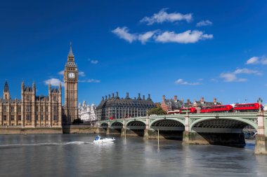 Büyük Ben, Thames nehri üzerindeki köprüde kırmızı otobüslerle Londra, İngiltere, İngiltere 'de tekneyle.