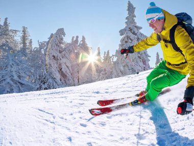 Yokuş aşağı mavi gökyüzü karşı yüksek dağlarda kayak kayakçı.