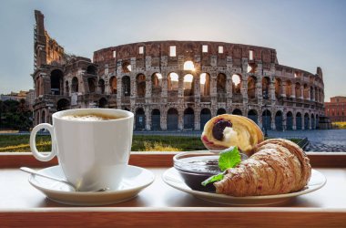 Roma, İtalya 'da ünlü Colosseum kruvasanla bir fincan taze kahveye karşı.