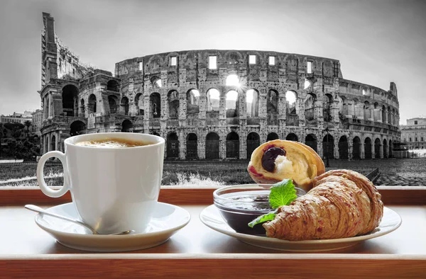 イタリアのローマでクロワッサンと新鮮なコーヒーのカップに対する有名なコロッセオ — ストック写真