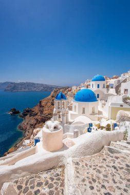 Oia village with churches against Aegean sea on Santorini island in Greece