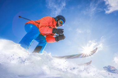 Skier skiing downhill in high mountains against against the fairytale winter forest.