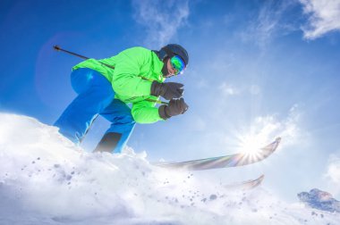 Skier skiing downhill in high mountains against against the fairytale winter forest.