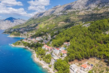 Brela, Hırvatistan, Dalmaçya ve Hırvat gök mavisi sahillerinde kayık ve gök mavisi deniz manzaralı Punta Rata sahili