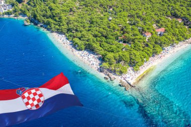 Hırvatistan 'da Adriyatik temiz deniz suyu ve beyaz kumsalda Hırvat bayrağıyla Punta Rata plajı