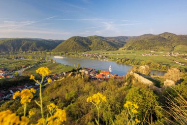 Avusturya 'nın Wachau kentinde bahar zamanı Tuna nehrinin yanında kamp alanına karşı kilisesi olan Durnstein köyü.