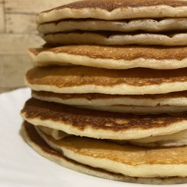 Beyaz tabakta çikolata soslu krep yığını.