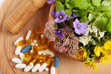 Taze otlu havan ve tahta tahtada haplar.