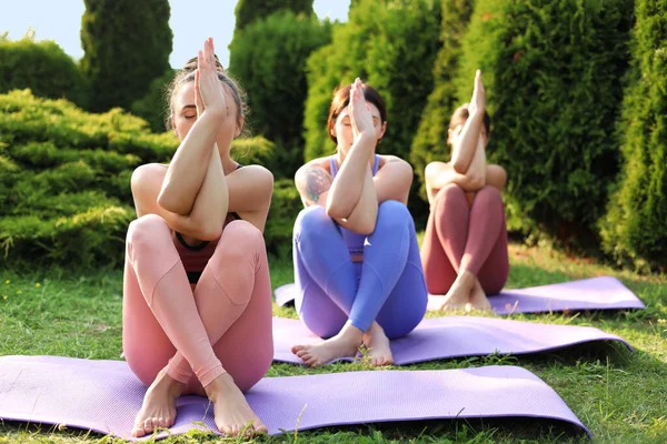 Paspaslarda yoga yapan genç kadınlar.