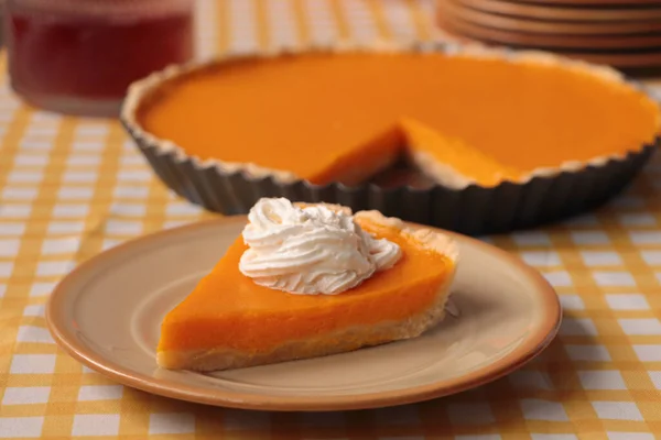 stock image Piece of fresh homemade pumpkin pie with whipped cream on table