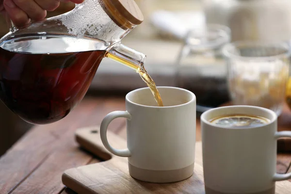 Налить Вкусный Чай Чашку Деревянный Стол Крупным Планом — стоковое фото