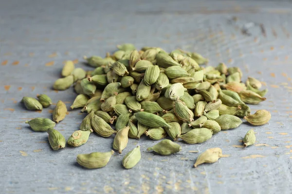 Pile of dry cardamom pods on grey wooden table