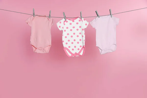 Baby Rompertjes Drogen Waslijn Tegen Roze Achtergrond — Stockfoto