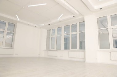 Beyaz duvarları ve pencereleri olan modern ofis odası. İç tasarım