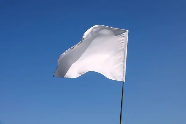 stock image White flag fluttering against blue sky on sunny day