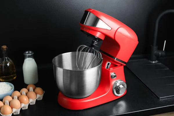 Modern stand mixer and ingredients on countertop in kitchen. Home appliance