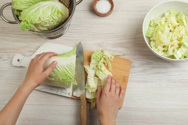 Vrouw Snijden Chinese Kool Witte Houten Keukentafel Bovenaanzicht — Stockfoto