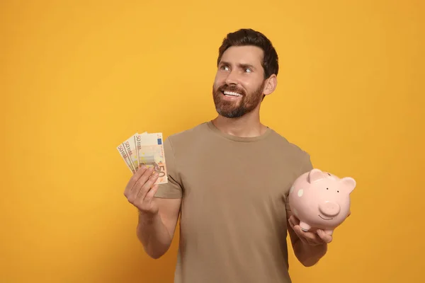 Happy Man Money Ceramic Piggy Bank Orange Background — Stock Photo, Image
