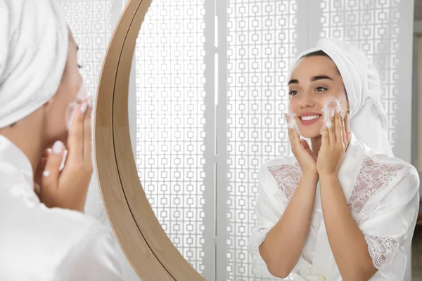 Vacker Ung Kvinna Applicera Rengöringsskum Ansiktet Nära Spegeln Badrummet Hudvård — Stockfoto