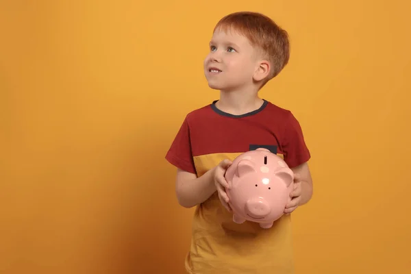 Cute Little Boy Ceramic Piggy Bank Orange Background Space Text — Stock Photo, Image